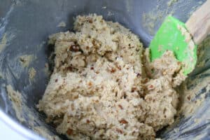 Stirring cookie dough in a bowl with spatula.