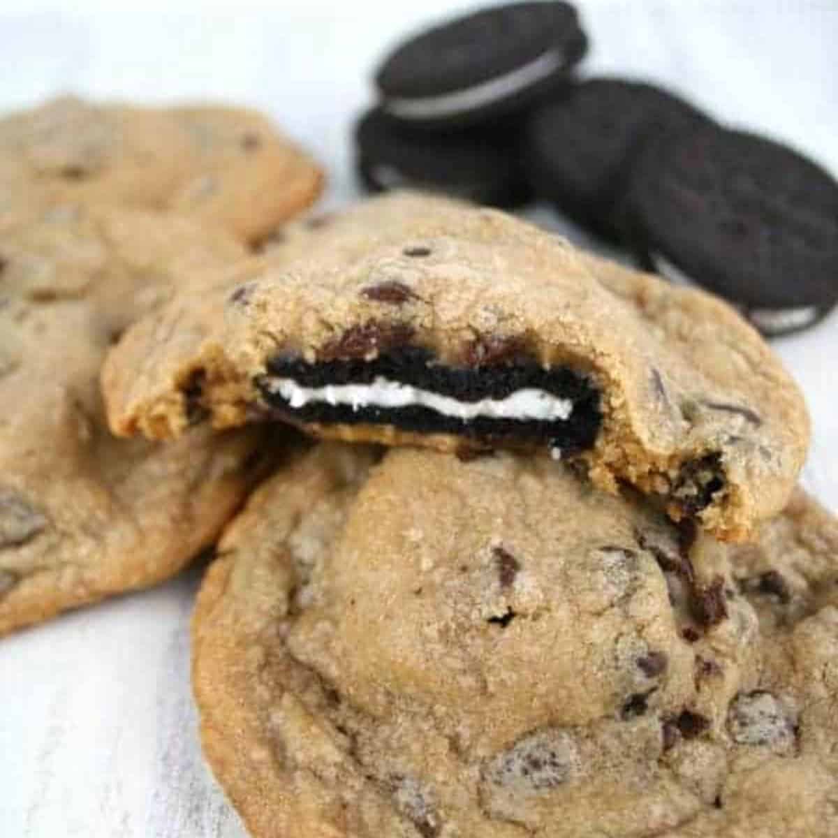 Oreo stuffed chocolate chip cookies with Oreos and one showing the inside of the cookie