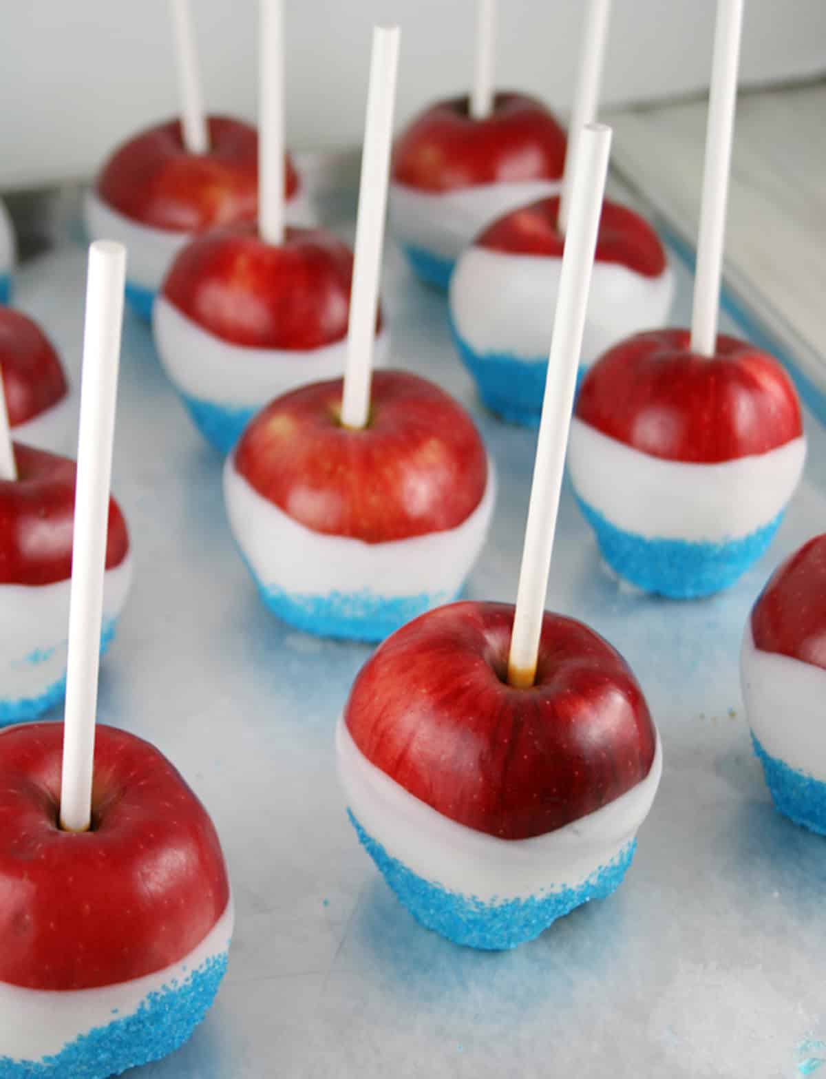 Red, white and blue candy apples on a july 4th dessert tray.