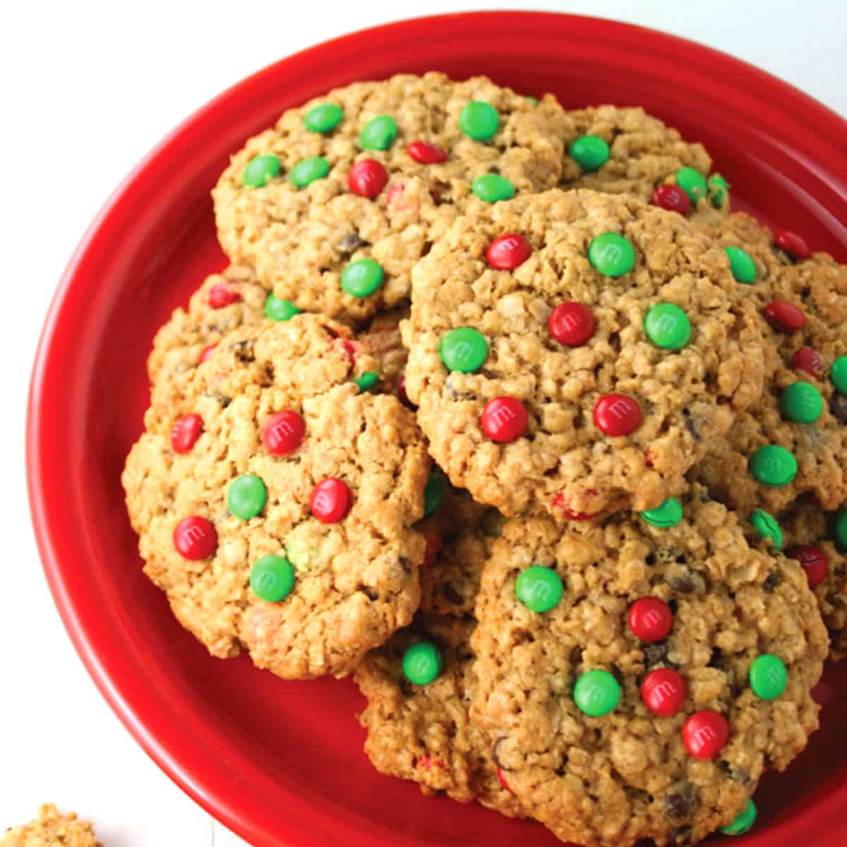 Pile of monster cookies on a red plate.