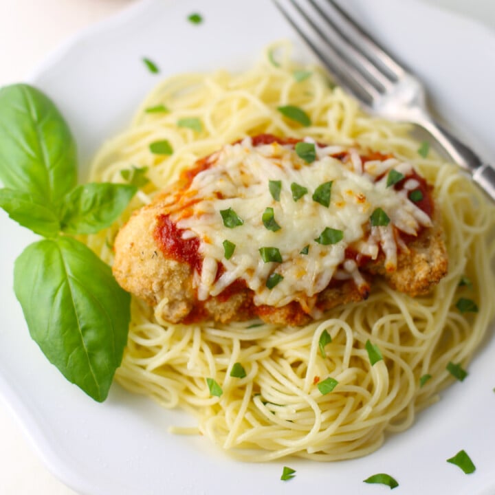 Chicken parm on a small white plate.