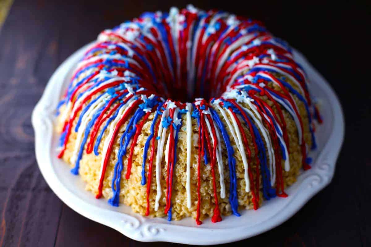 Rice krispy bundt cake on white plate on a dark brown table.