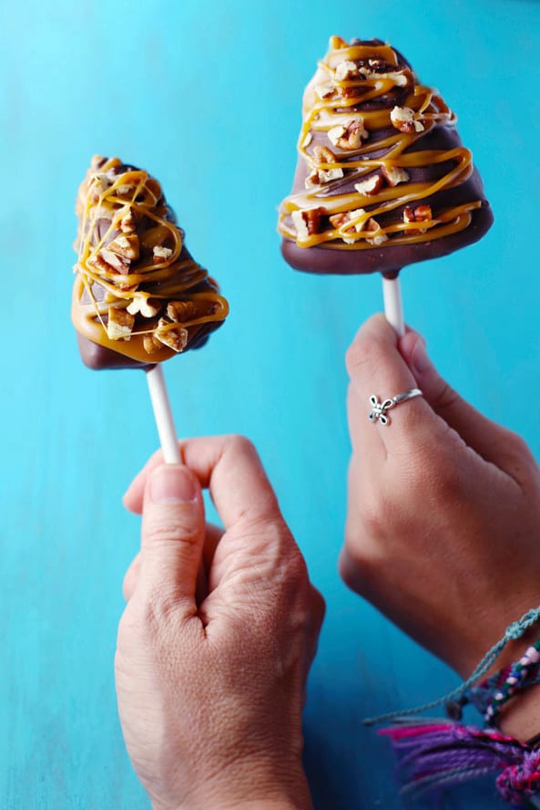 Hands hold cheesecake pops