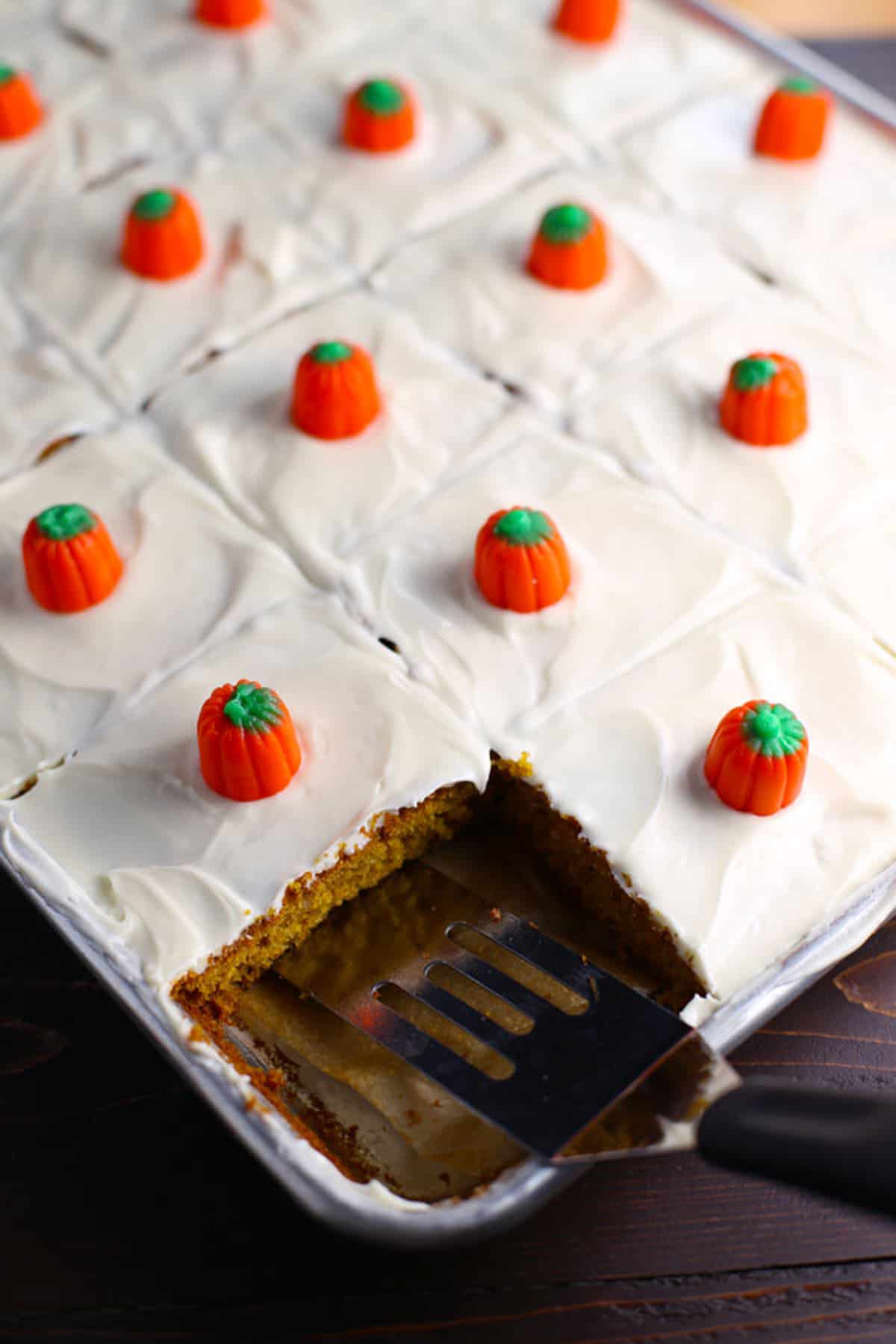 Sheet pan of pumpkin bars with candy pumpkins on top.