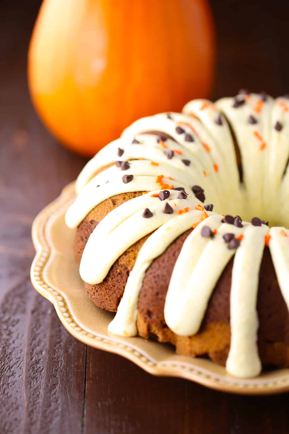 Cream cheese frosting glaze drizzled on pumpkin swirl cake.