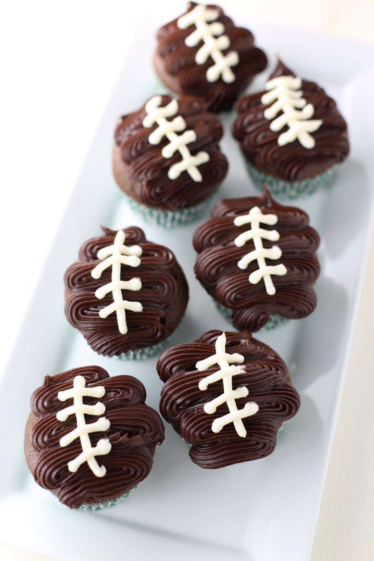White tray of Football cupcakes.