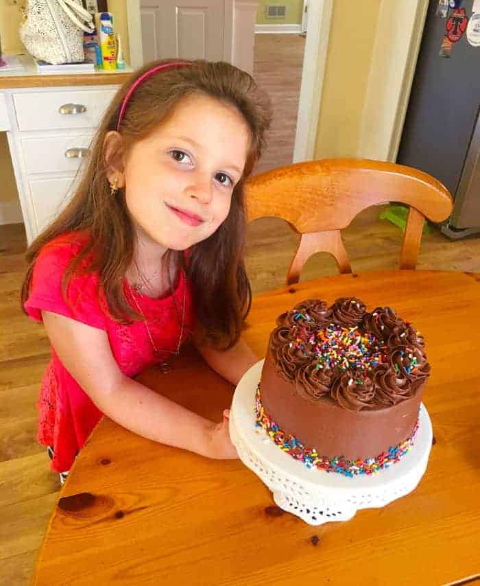 Little girl with chocolate birthday cake