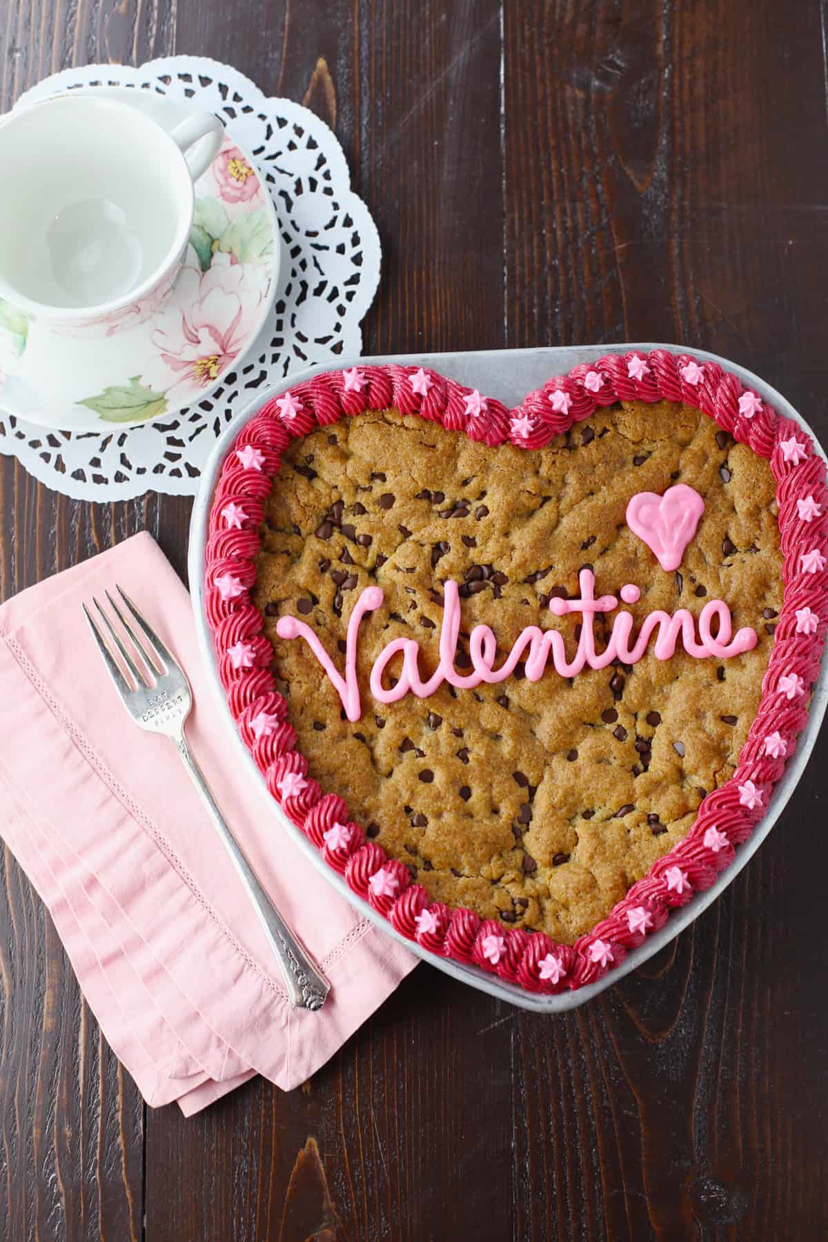 Heart cookie cake on table with pink napkn and fork.