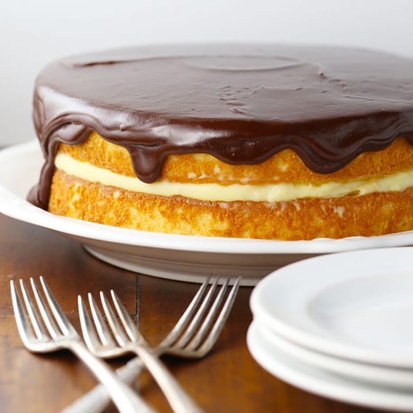 Boston cream pie birthday cake with plates and forks