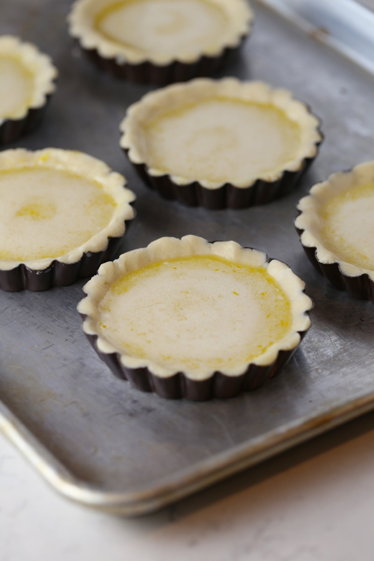 Mini tart crusts filled with lemon curd filling.