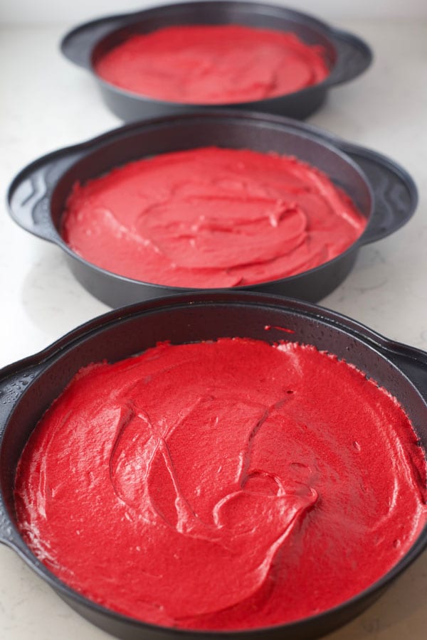 Red velvet cake batter in pans