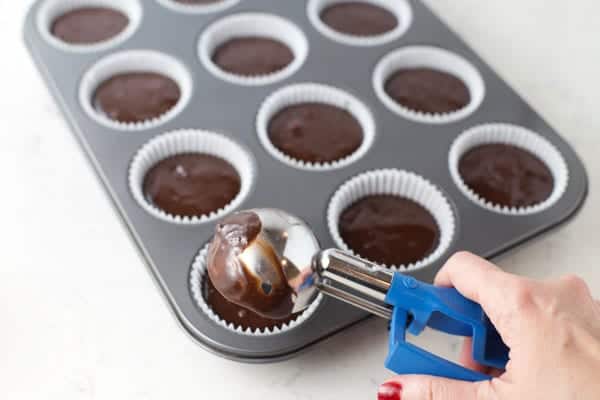 Scooping brownie batter into muffin cups