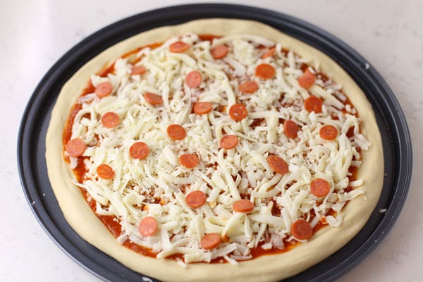 Add cheese to pizza dough crust