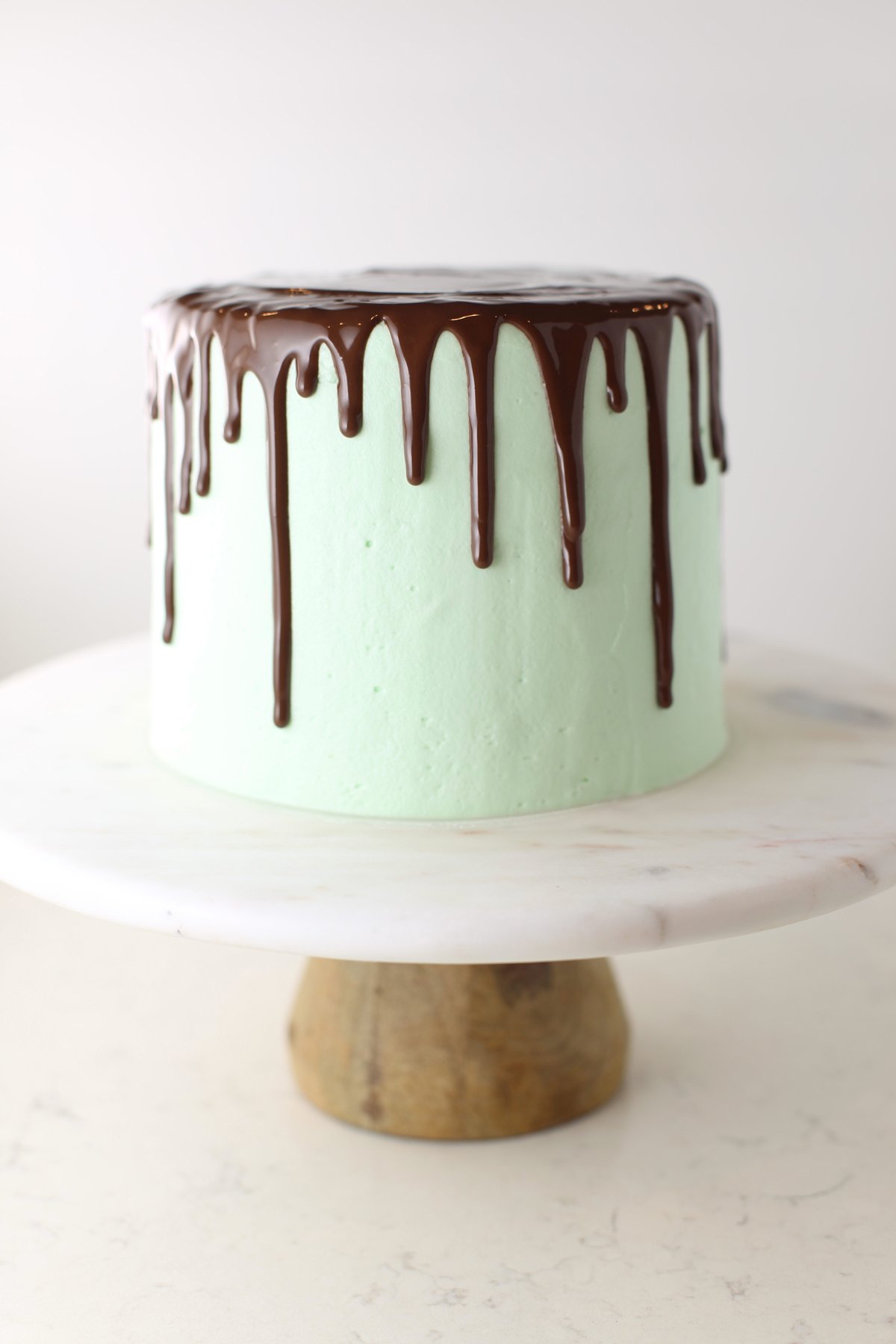 Chocolate drip icing on mint frosted cake.