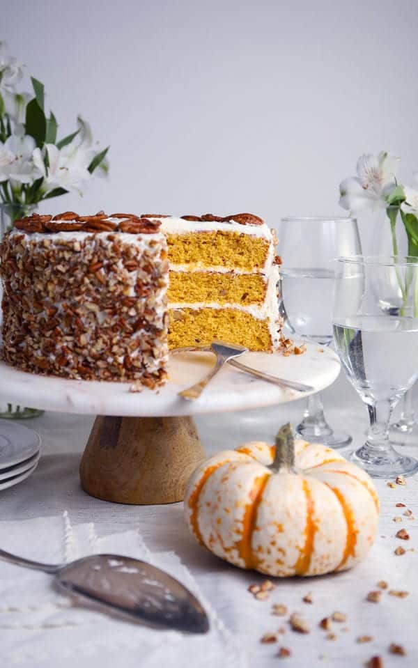 Pumpkin spice pecan layer cake with cream cheese frosting on cake stand