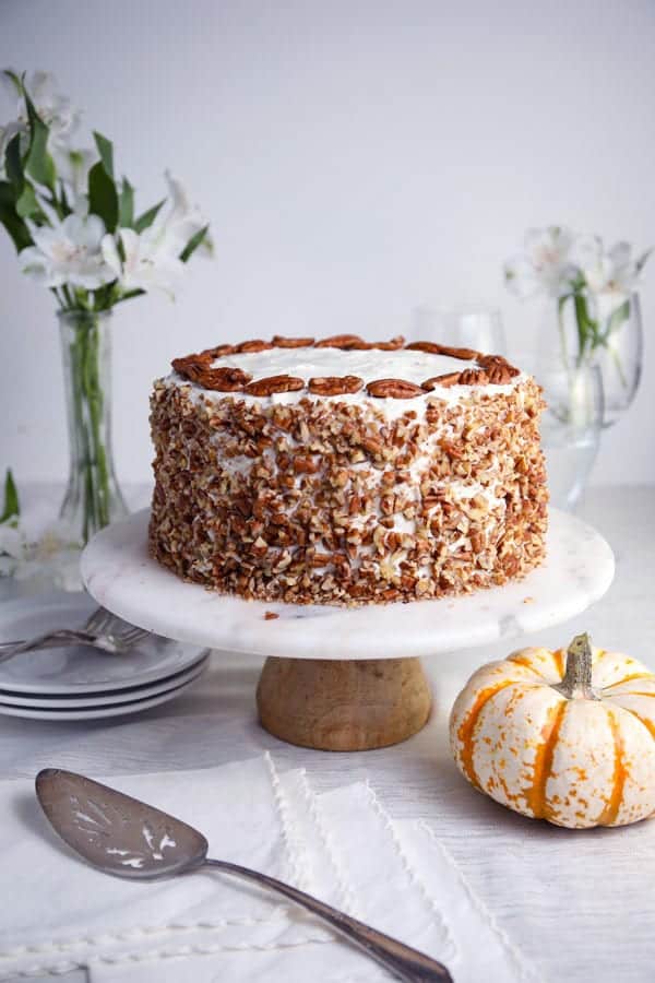 Pumpkin spice pecan layer cake with cream cheese frosting covered with chopped pecans recipe