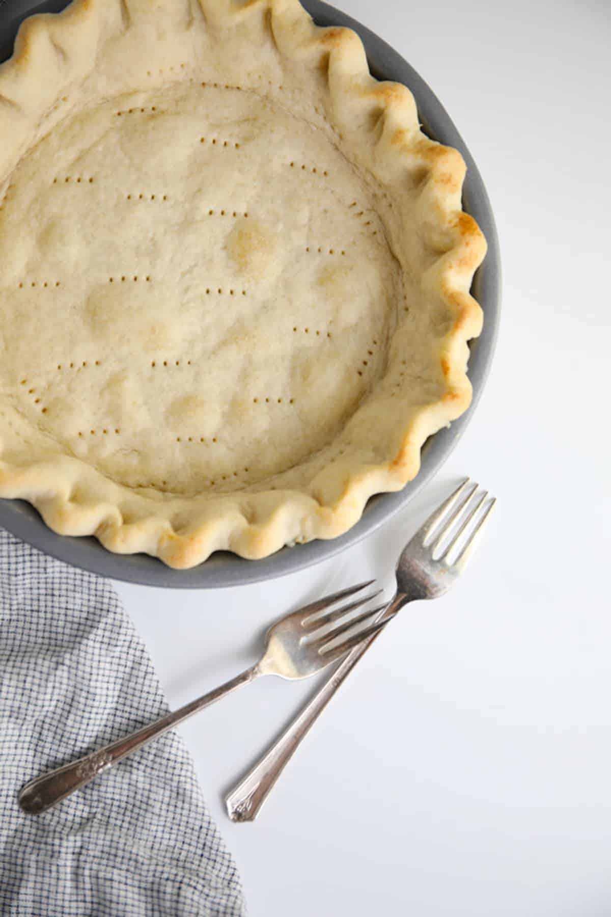 Baked pie crust with two forks on the side.