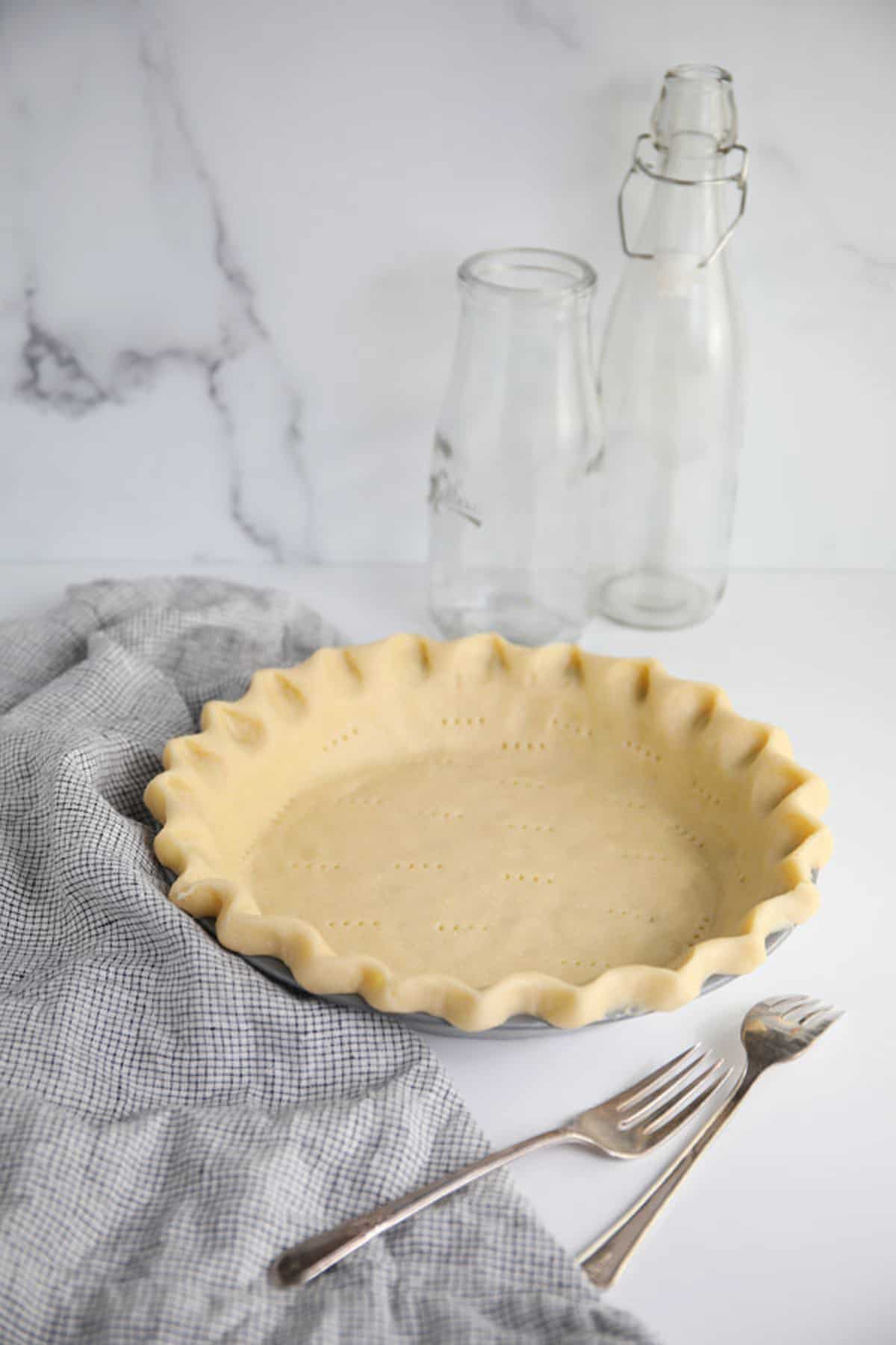 Perfect foolproof flaky pie crust in pan on counter.