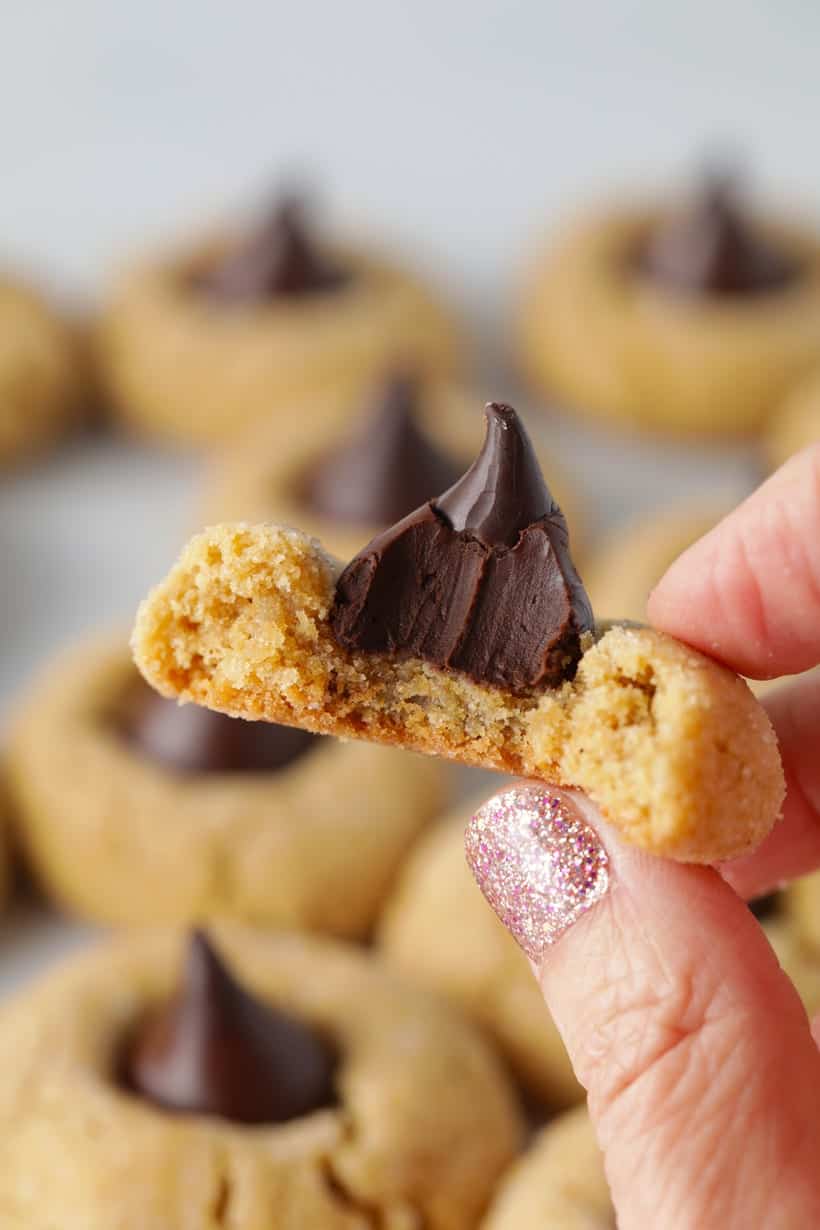 Peanut butter blossom cookie with a bite taken out showing the inside of cookie.