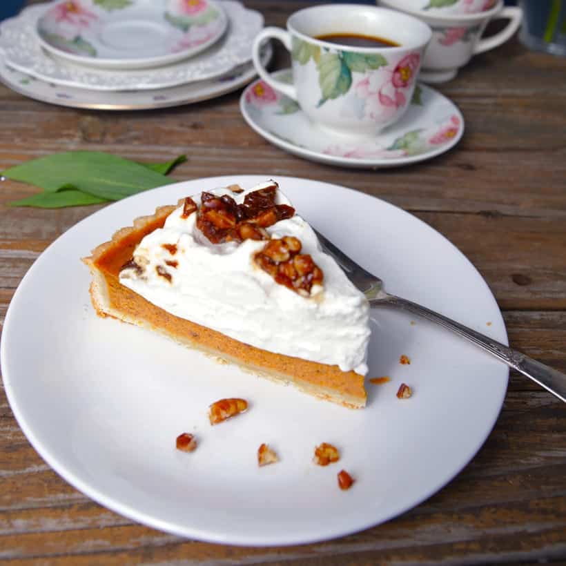 Slice of pumpkin pie with whipped cream and pecan toffee