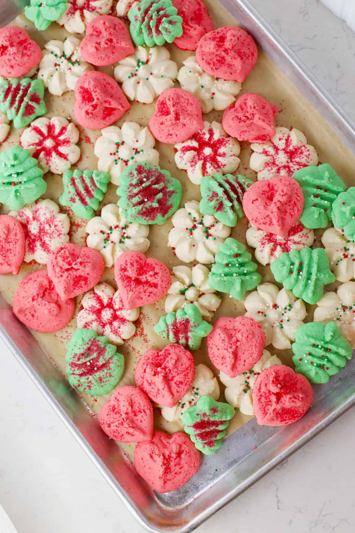 Cookie sheet with baked Christmas cookies on it.
