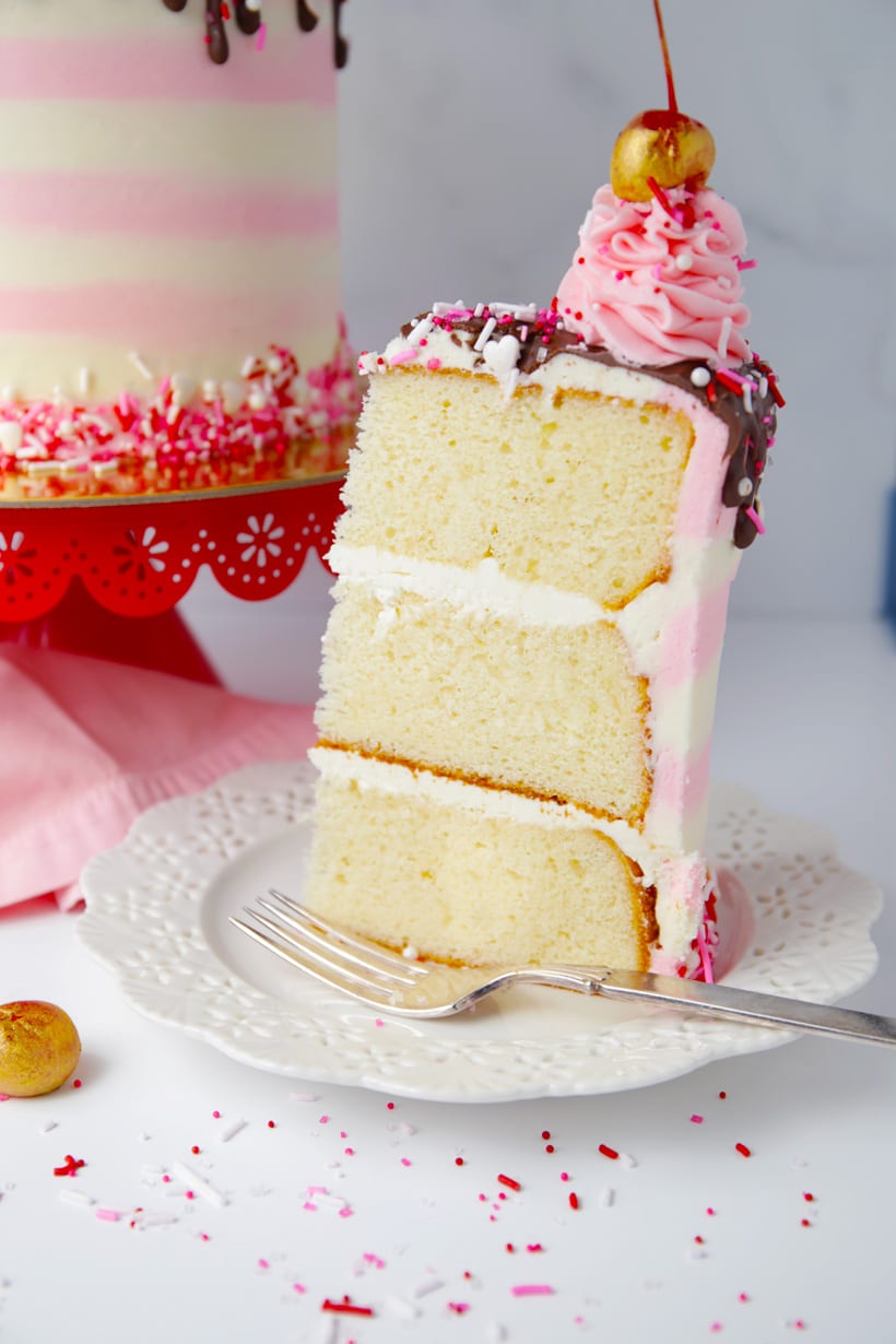 Slice of three layer vanilla cake with buttercream cake