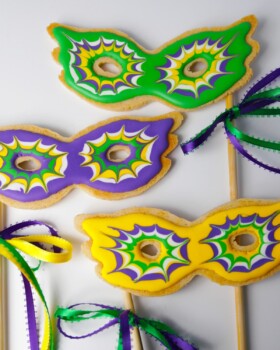 Mardis gras mask cookies on a stick in green purple yellow
