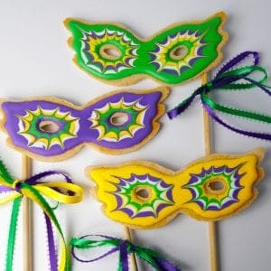 Mardis gras mask cookies on a stick in green purple yellow