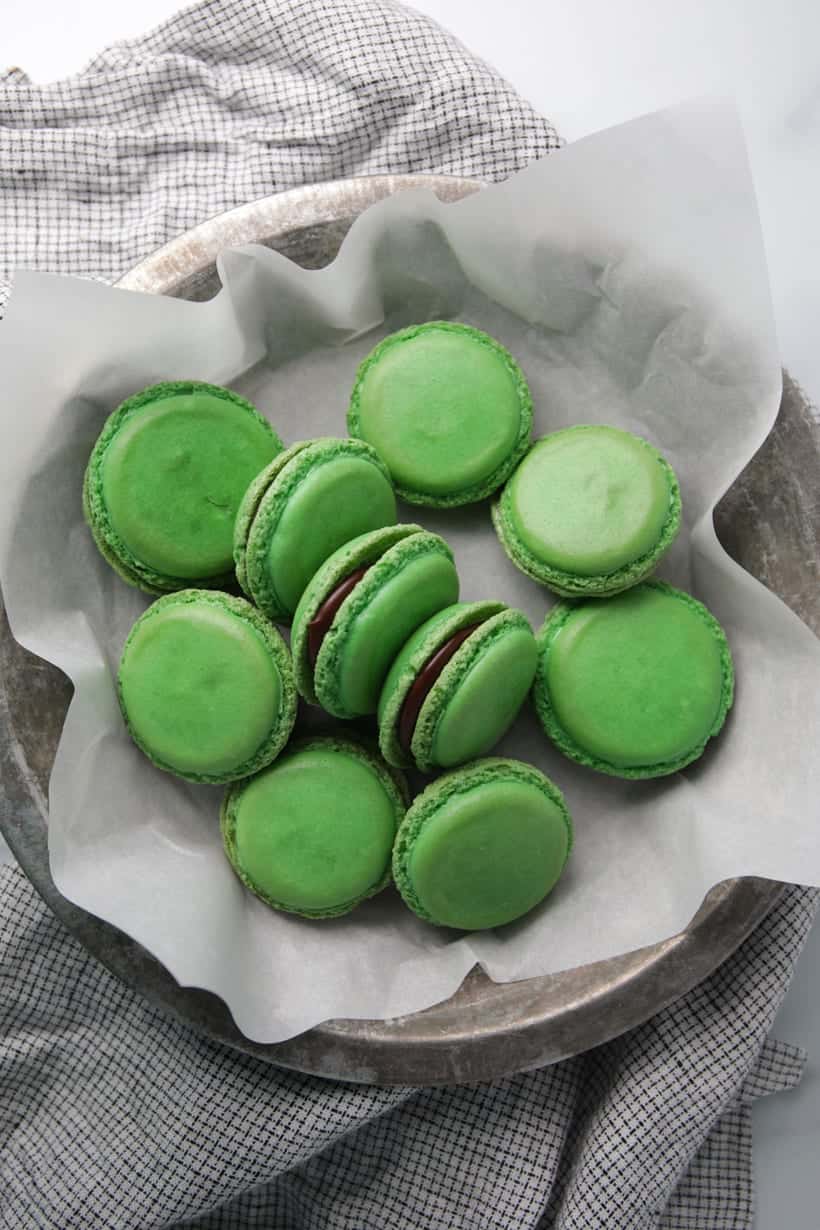 Mint chocolate filled green macaron shells in pie plate