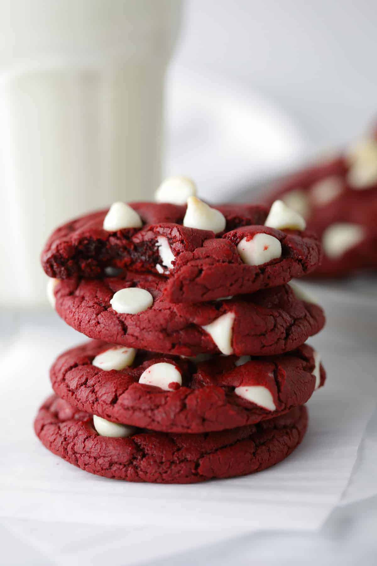 Stack of four cookies with bite taken out of top one.