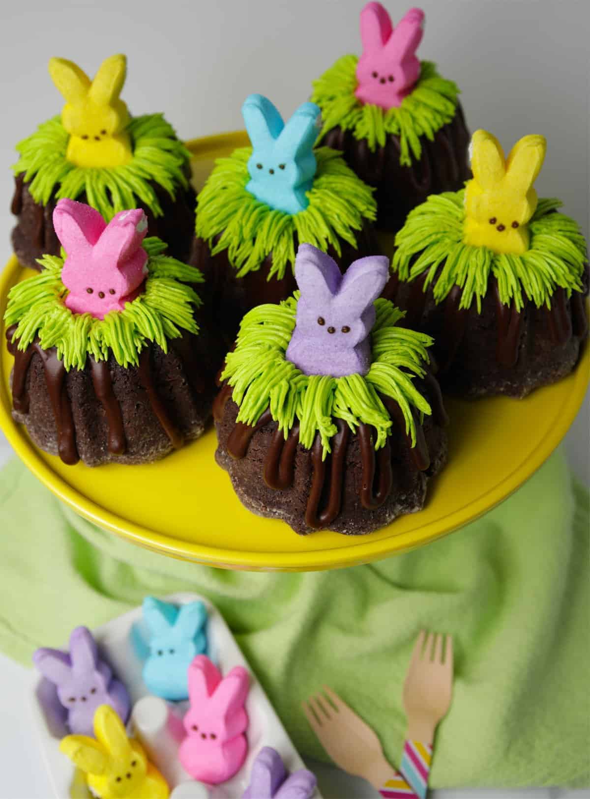 Mini chocolate Bundt cakes with green buttercream grass and Peeps on top.