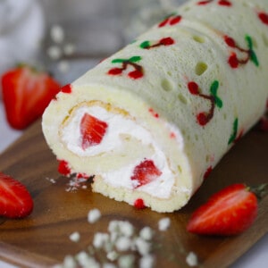 Vanilla cake roll with cherry design on the top.
