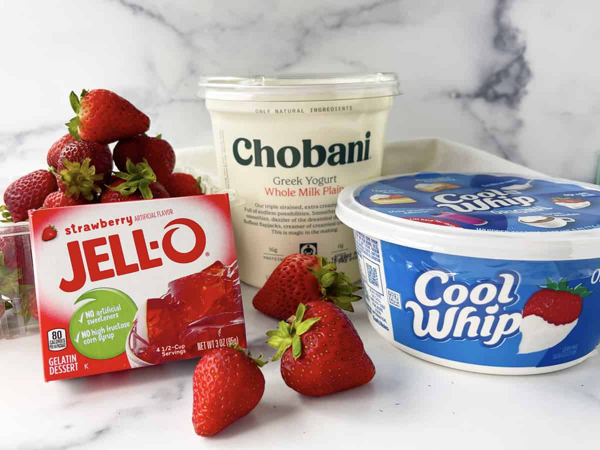 Box of Jello, fresh strawberries, Chobani Greek Yogurt and tub of Cool Whip on counter.
