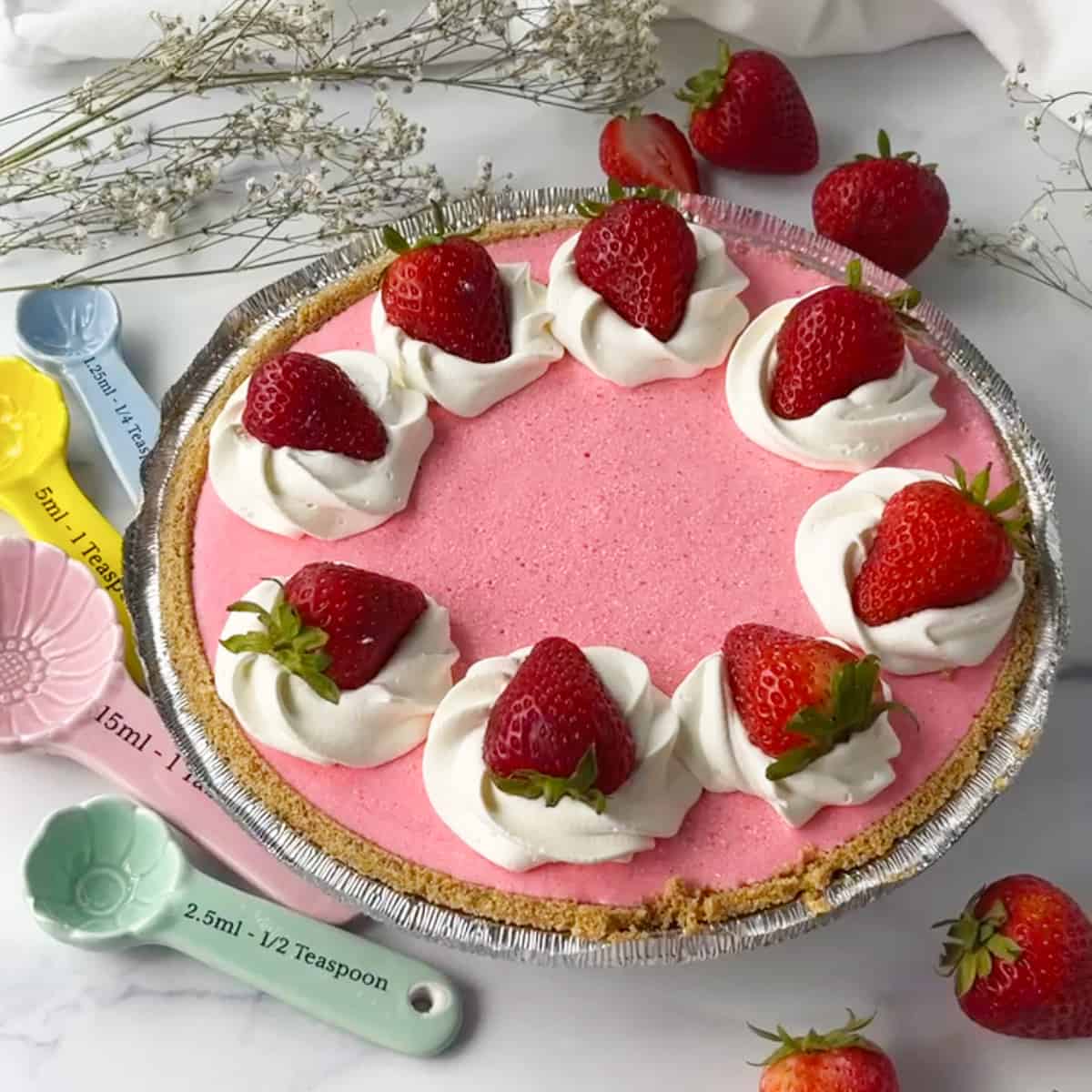 Cool whip pie in graham cracker crust with strawberries on top.