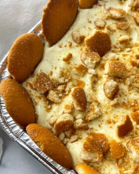 Close up shot of tray of banana pudding with vanilla wafers around the edge.