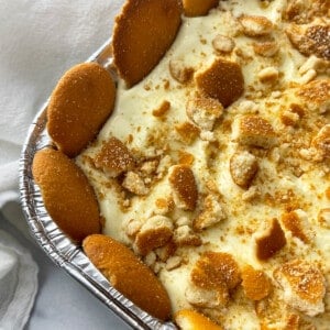 Close up shot of tray of banana pudding with vanilla wafers around the edge.