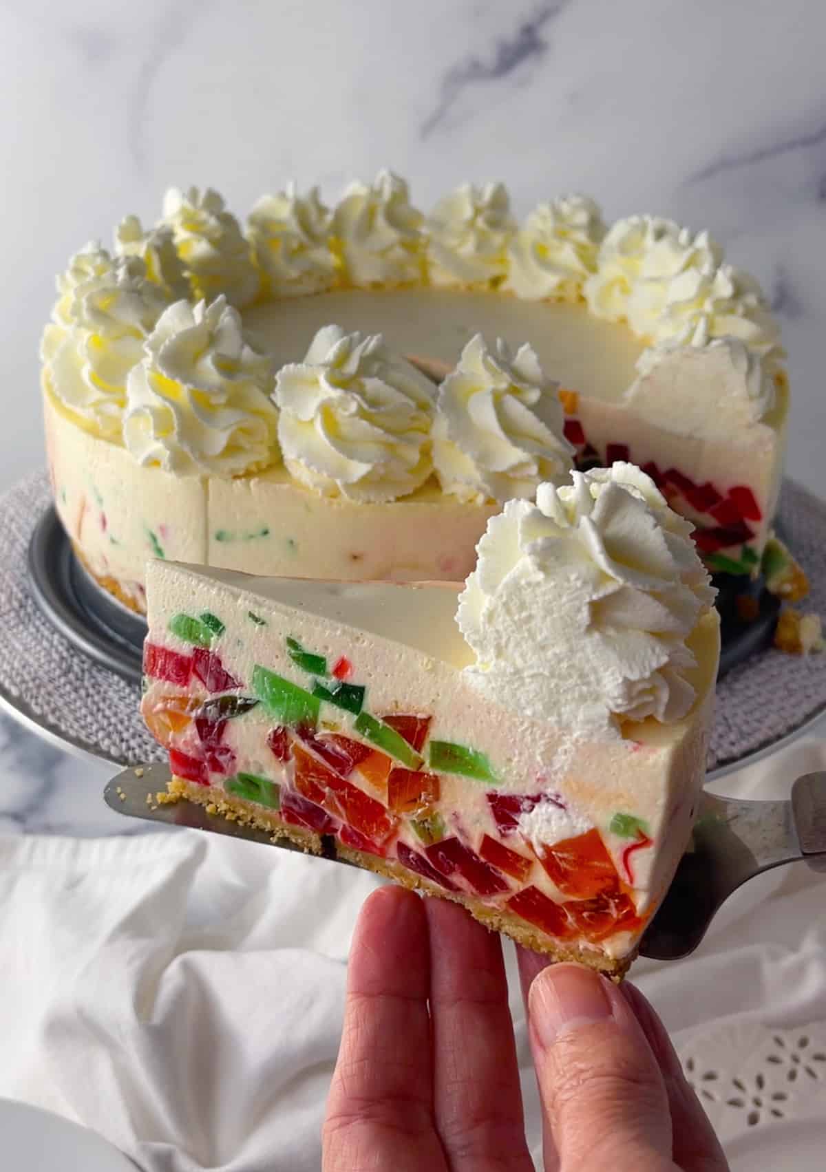 Rainbow jello cake with whipped cream.