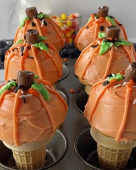 Muffin pan with six pumpkin ice cream cone cupcakes in it.