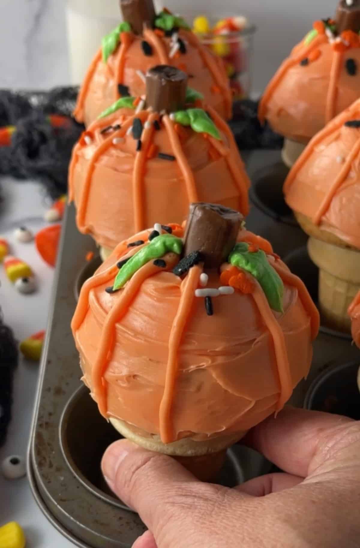 Cake batter baked in cones and decorated to look like pumpkins.