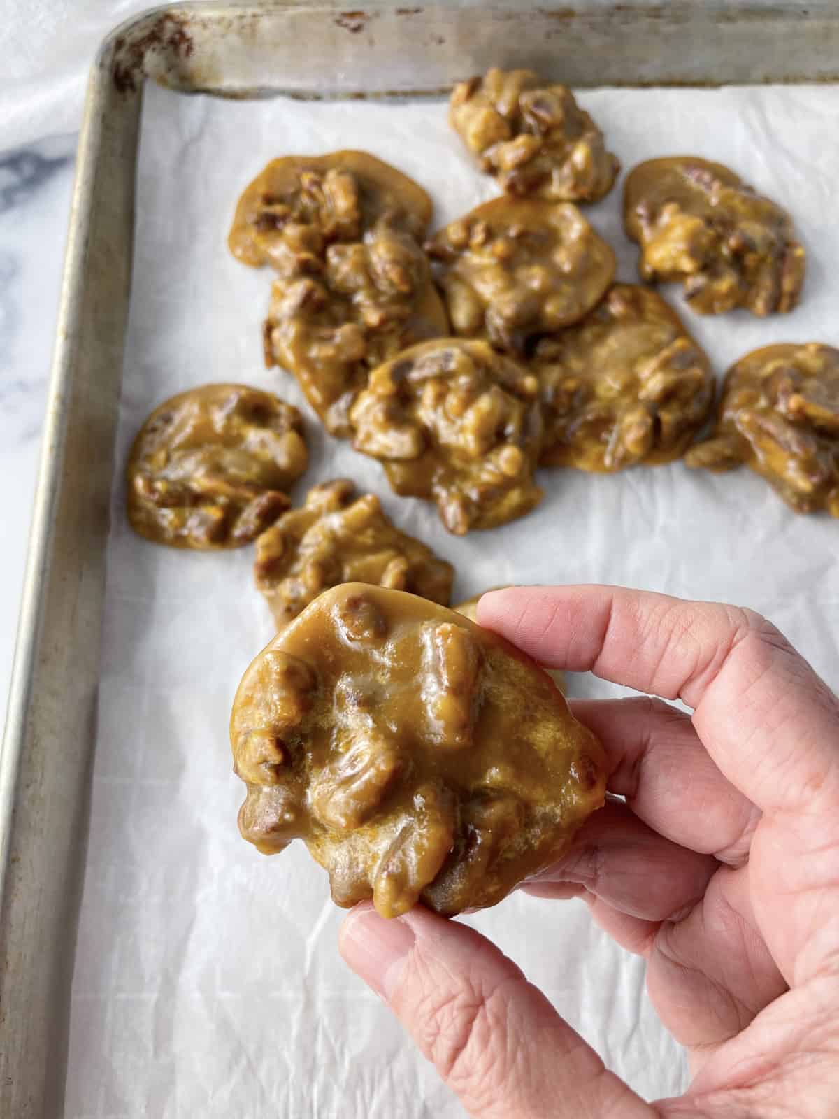 Pecan praline candies on a sheet pan with parchment paper.