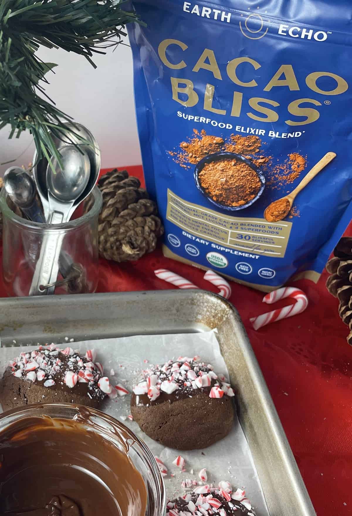 Dipped cookies on a baking sheet with bag of Cacao Bliss in the background.
