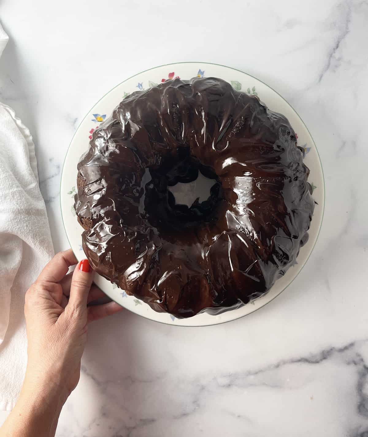 Chocolate glazed cake on white plate.