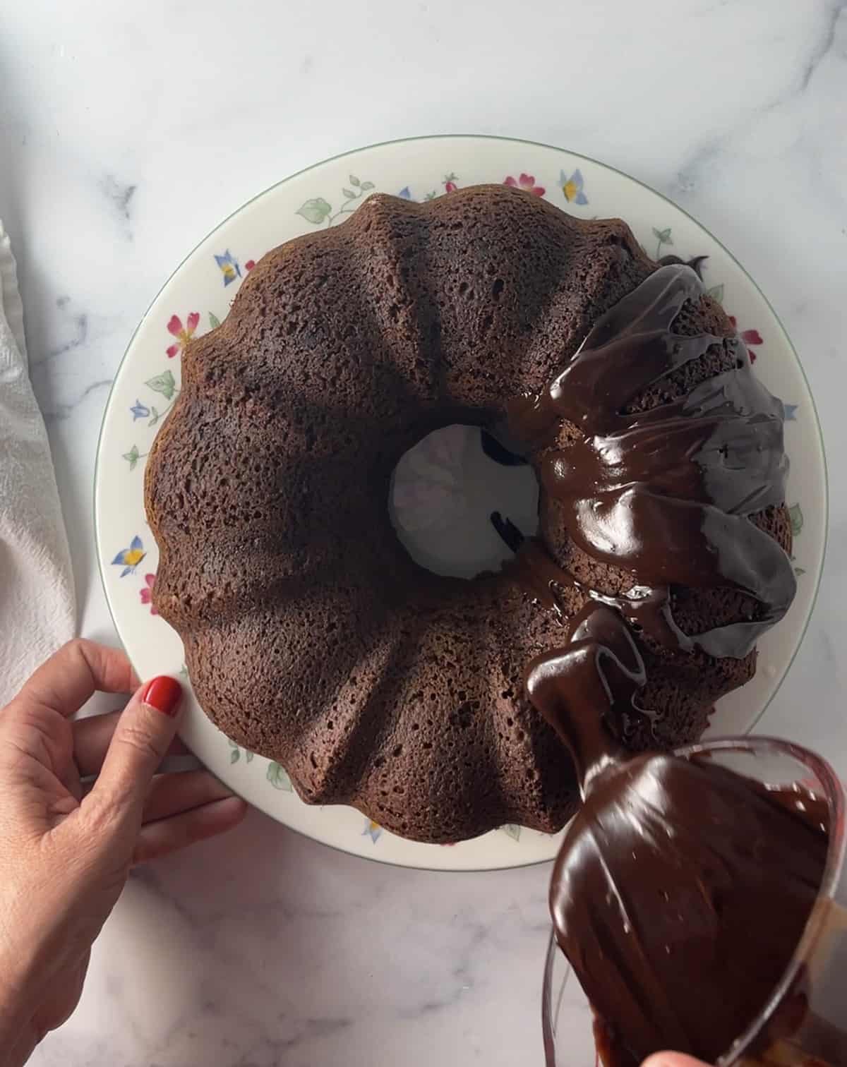 Frosting a chocolate chip Bundt cake.