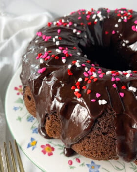 Chocolate Bundt Cake on a white plate with flowers.