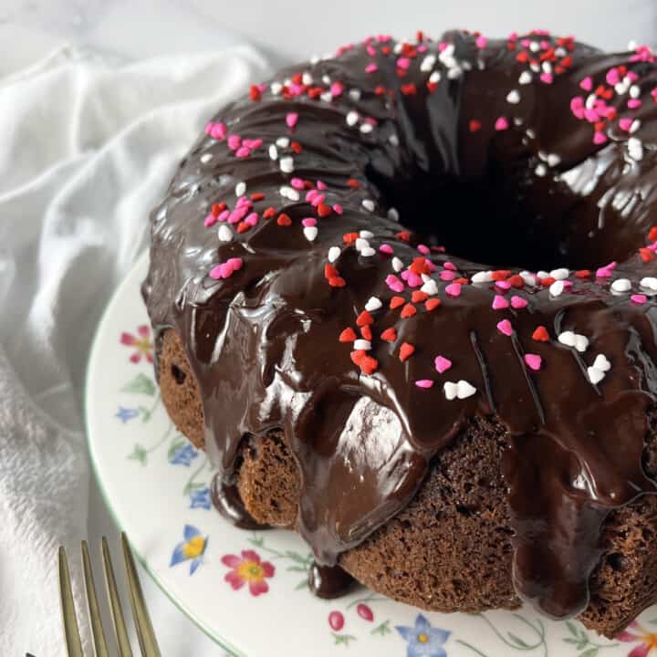 Chocolate Bundt Cake on a white plate with flowers.