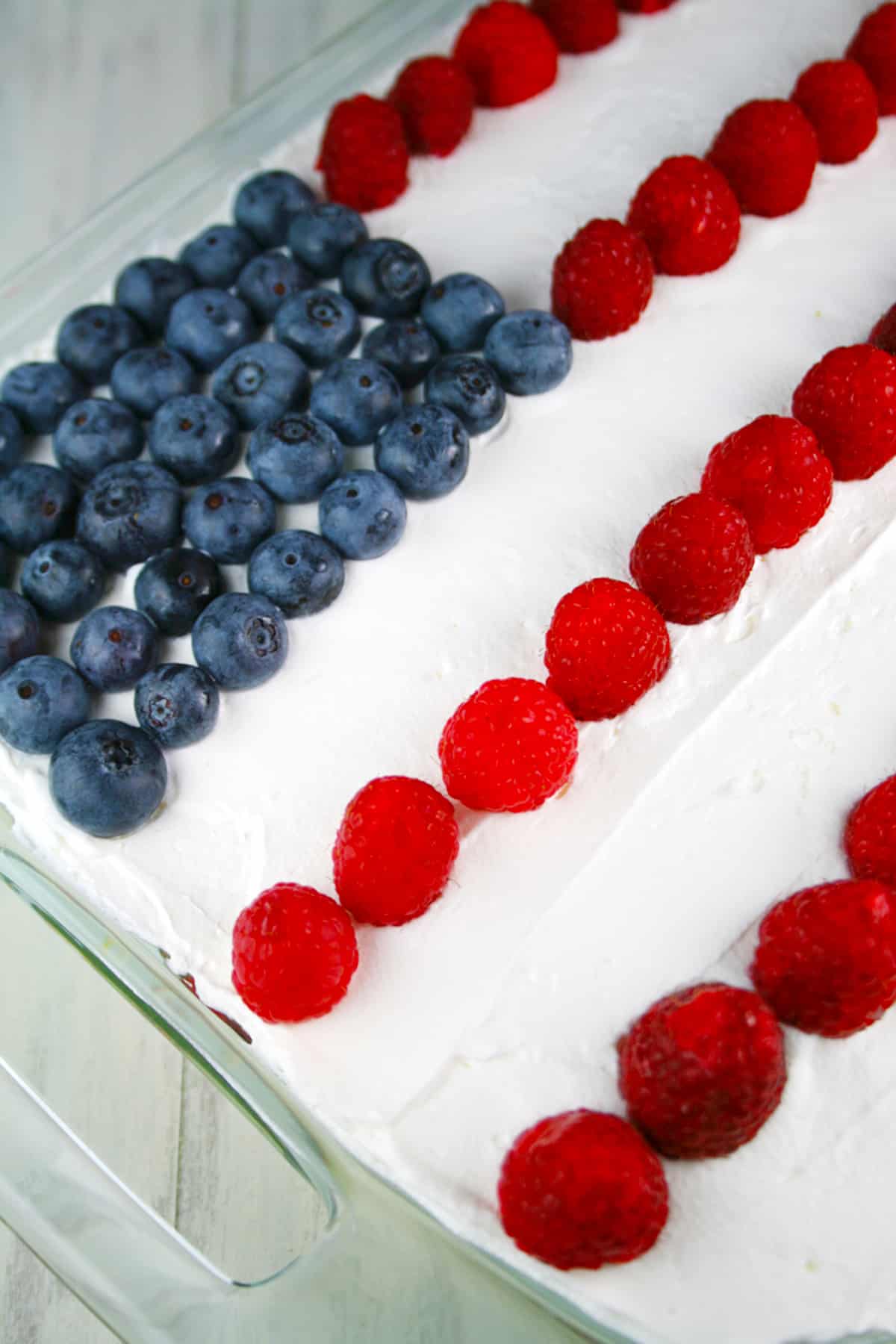 Close up photo of the top of no bake flag cake with blueberries and raspberries.