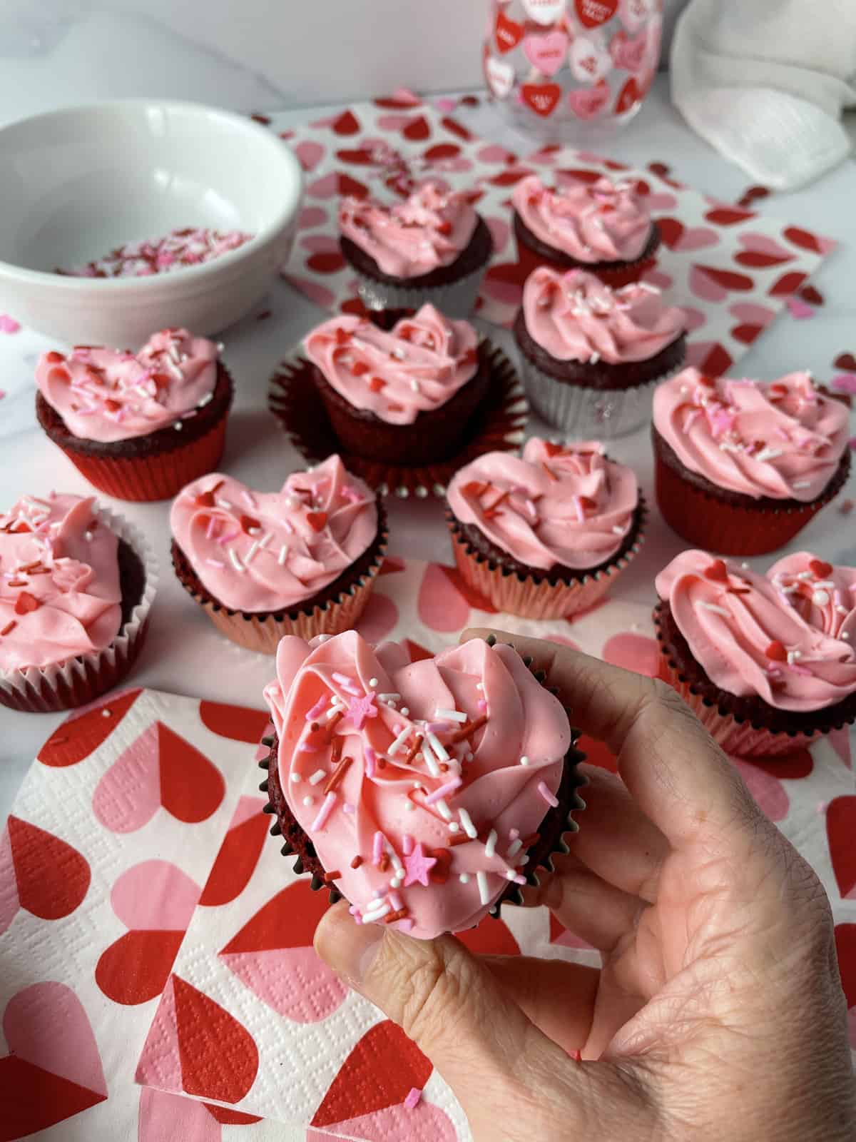 Red velvet cupcakes with strawberry frosting for valentine's day treat.