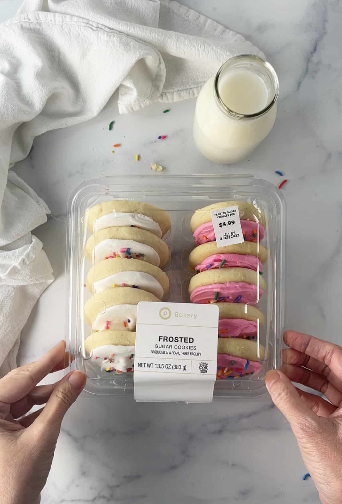 Clear plastic cookie box with one dozen of this Copycat Lofthouse Soft Frosted Sugar Cookies Recipe.