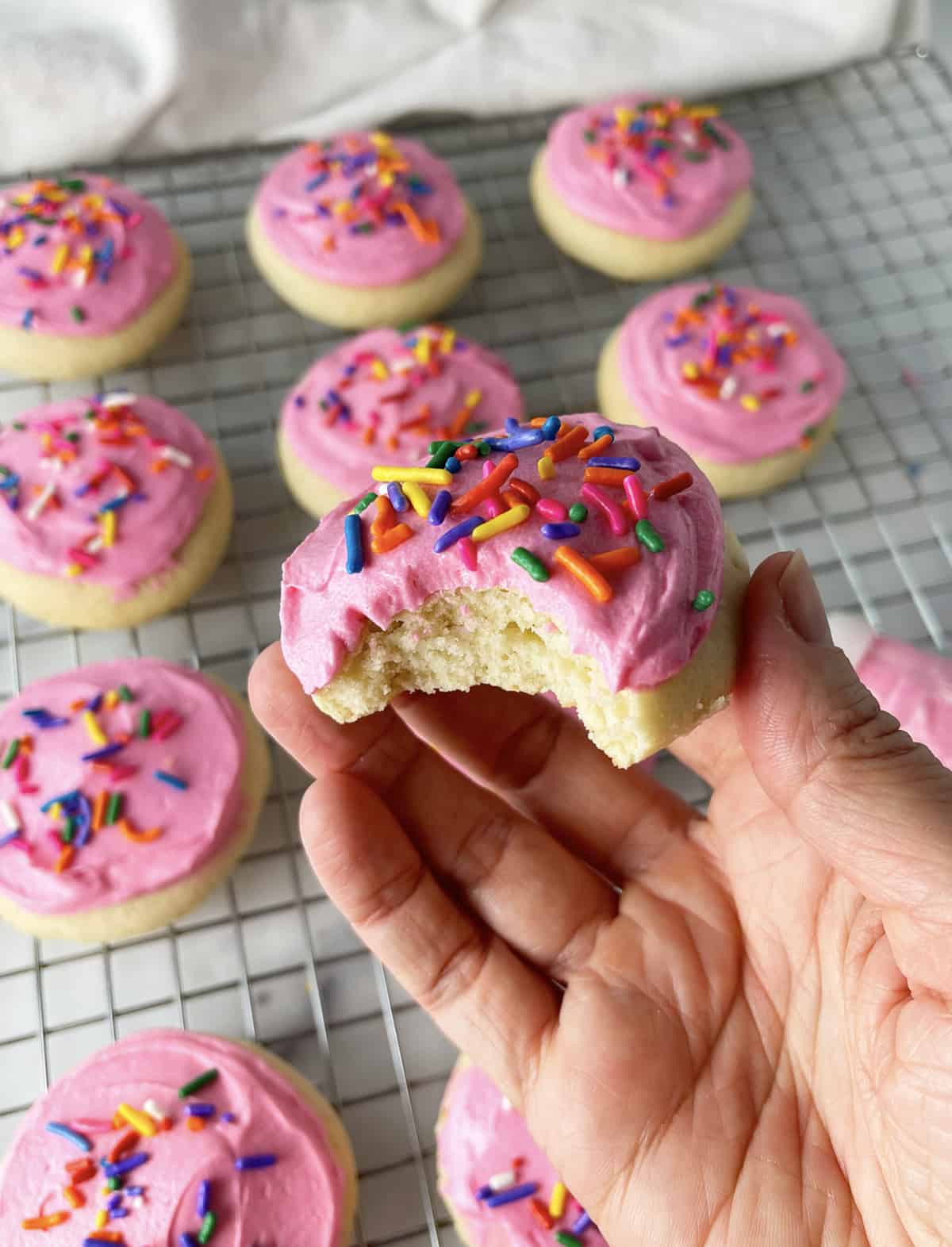 Lofthouse frosted cookies with one that has a bite taken out.