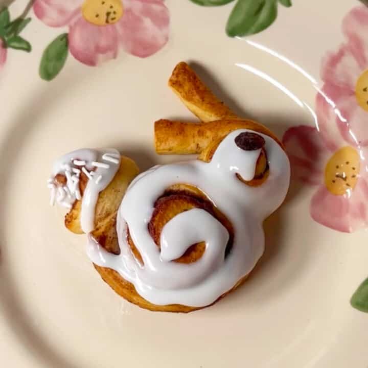 Bunny shaped cinnamon roll on a flowered plate.